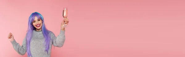 Fröhliche Frau mit gefärbten Haaren hält Glas Champagner auf rosa, Banner — Stockfoto
