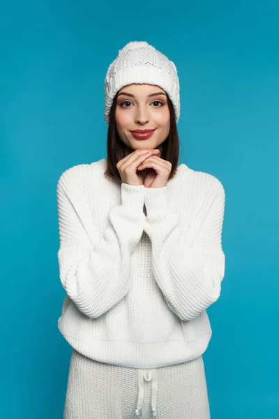 Pretty young woman in knitted clothes looking at camera isolated on blue — Stock Photo