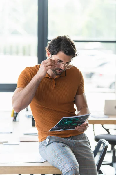 Businessman in eyeglasses looking at document in office — Stock Photo