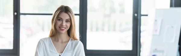 Feliz mujer de negocios mirando a la cámara en la oficina, pancarta - foto de stock