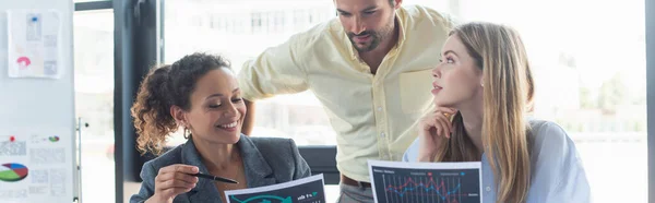 Geschäftsmann, der neben Kollegen steht, die mit Dokumenten im Büro arbeiten, Banner — Stockfoto