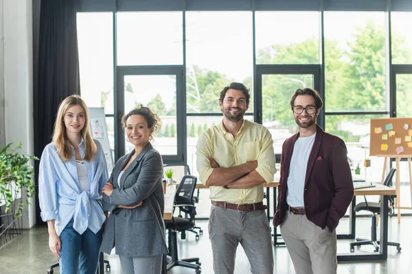Fröhliche multiethnische Geschäftsleute blicken im Büro in die Kamera — Stockfoto