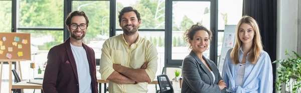 Interracial business people in formal wear smiling at camera in office, banner — Stock Photo