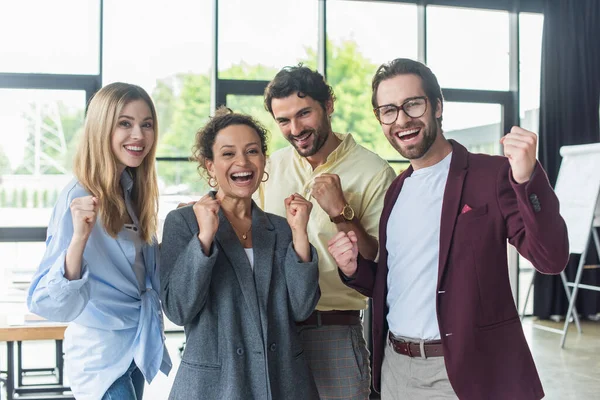 Excited interracial business people showing yes gesture at camera in office — Stock Photo
