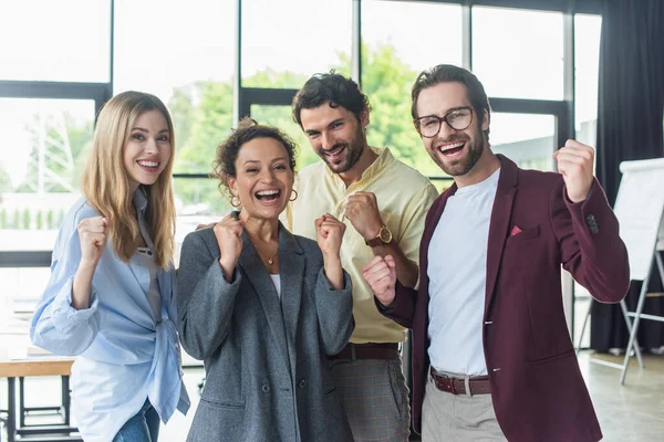 Aufgeregte interrassische Geschäftsleute zeigen im Büro vor laufender Kamera Ja-Geste — Stockfoto