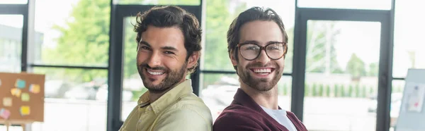 Lächelnde Geschäftsleute, die Rücken an Rücken im Amt stehen, Banner — Stockfoto