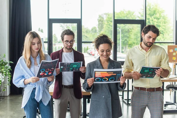 Multiethnic business people looking at documents with charts in office — Stock Photo