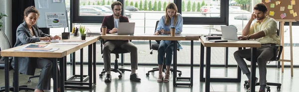 Personas de negocios multiétnicos que trabajan con documentos y computadoras portátiles en la oficina, pancarta - foto de stock