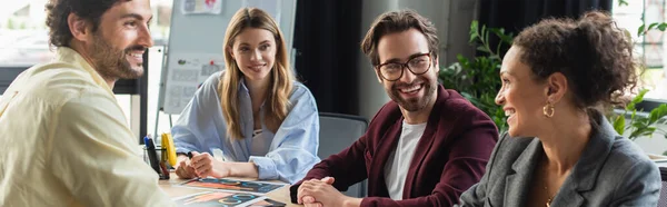 African american businesswoman smiling at colleagues near documents in office, banner — Stock Photo