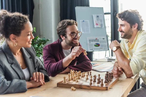 Gens d'affaires interraciaux positifs jouant aux échecs au bureau — Photo de stock
