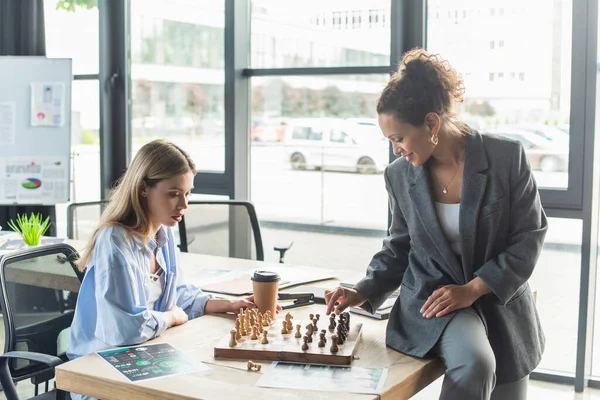 Afroamerikanische Geschäftsfrau spielt Schach mit junger Kollegin im Büro — Stockfoto