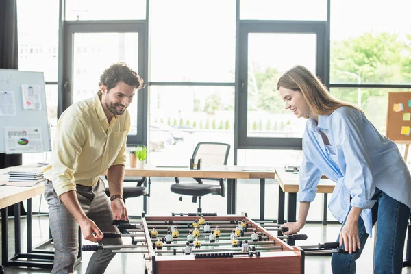 Empresário jogando futebol de mesa com jovem colega no escritório — Fotografia de Stock