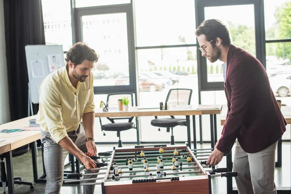 Businessmen in formal wear playing table soccer in office — Stock Photo