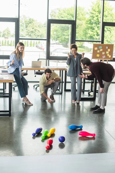 Gens d'affaires multiethniques montrant un geste oui tout en jouant au bowling au bureau — Photo de stock