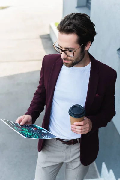 Молодий бізнесмен тримає каву, щоб піти і документувати на відкритому повітрі — стокове фото