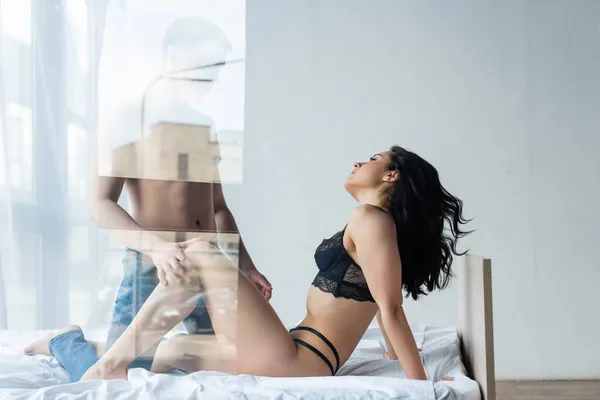 Man touching leg of seductive woman behind window glass — Stock Photo