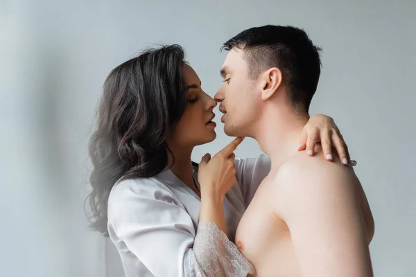 Vista lateral da jovem mulher beijando o homem no quarto — Fotografia de Stock