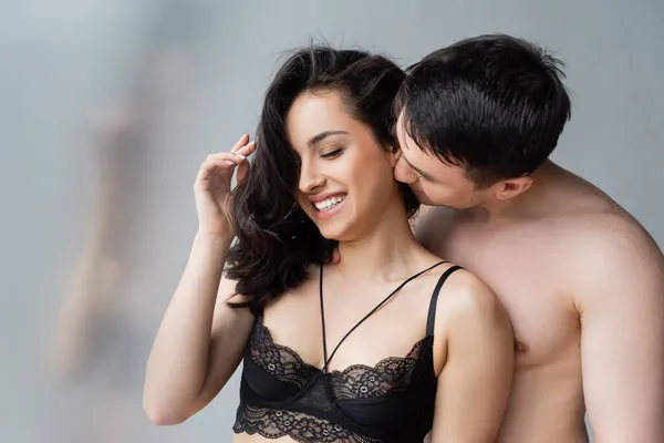 Hombre sin camisa seducir a la mujer alegre en sujetador de encaje negro - foto de stock