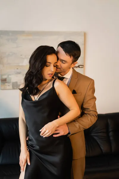 Man in suit seducing brunette woman in slip dress — Stock Photo