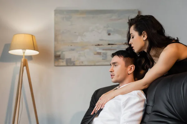 Vista laterale della giovane donna sexy sedurre l'uomo sul divano — Foto stock