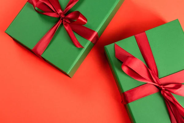 Draufsicht auf grün verpackte Geschenke auf rotem Hintergrund — Stockfoto