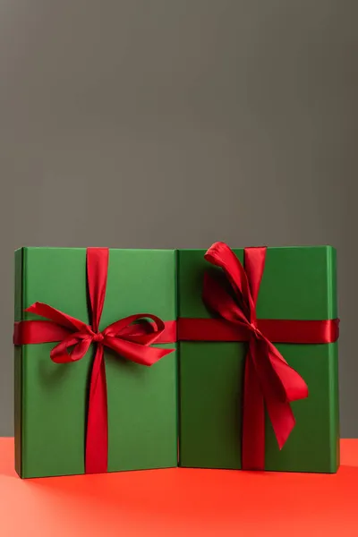 Green wrapped presents on red surface isolated on grey — Stock Photo