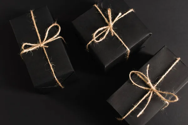 Vista dall'alto di scatole regalo scure avvolte su nero — Foto stock