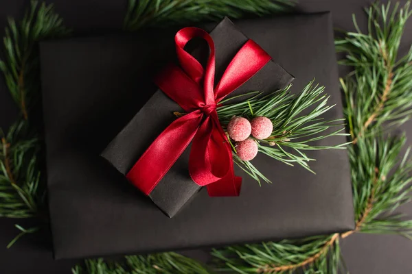 Top view of gift box with red ribbon and decoration on black — Stock Photo