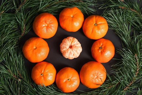 Plat posé avec des mandarines mûres près de boules de Noël dorées près des branches de sapin — Photo de stock