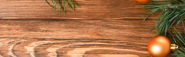 Vista dall'alto della palla di Natale dorata vicino ai rami di abete sulla superficie di legno, banner — Foto stock