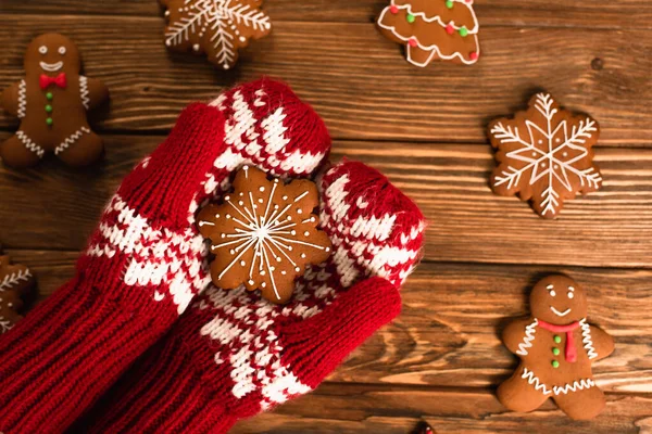 Cropped view of person in red mittens holding gingerbread cookie — Stock Photo