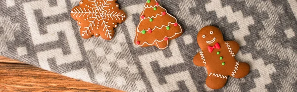 Top view of gingerbread cookies on grey blanket with ornament, banner — Stock Photo