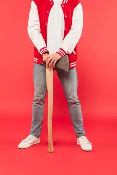 Cropped view of man holding axe while standing on red — Stock Photo