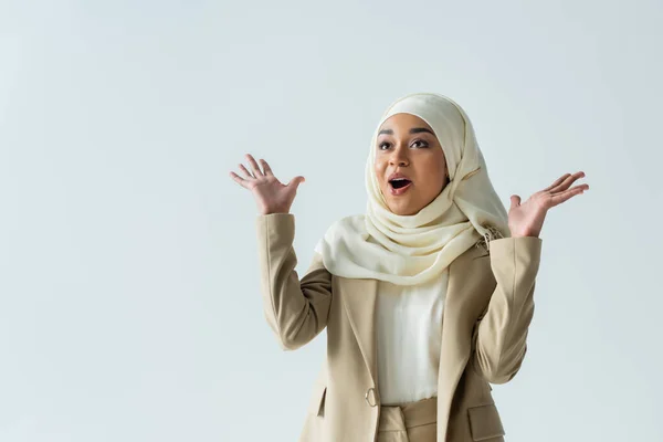 Donna musulmana stupita in hijab e abito beige gesticolando isolato sul grigio — Foto stock