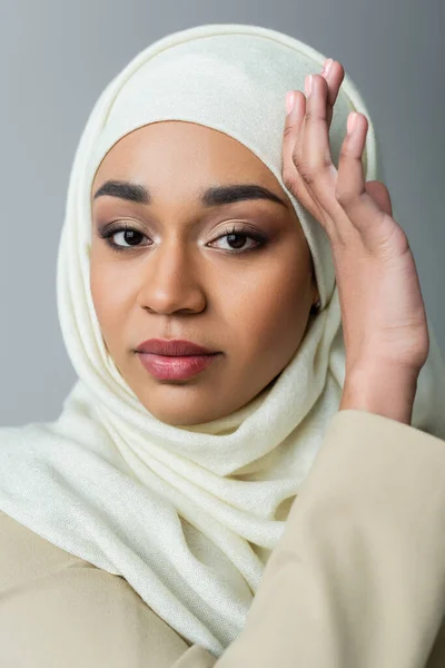 Portrait of muslim woman in hijab looking at camera isolated on grey — Stock Photo