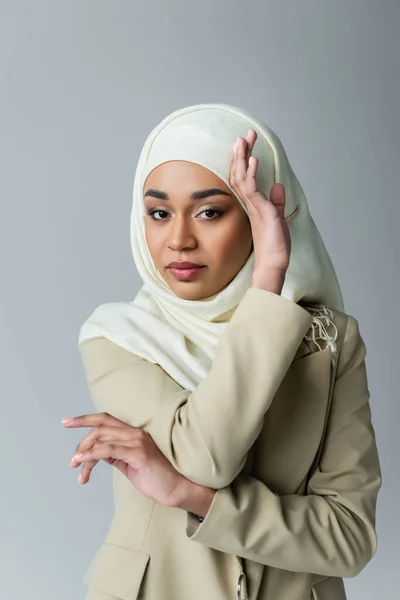 Portrait of muslim woman in hijab looking at camera while posing isolated on grey — Stock Photo