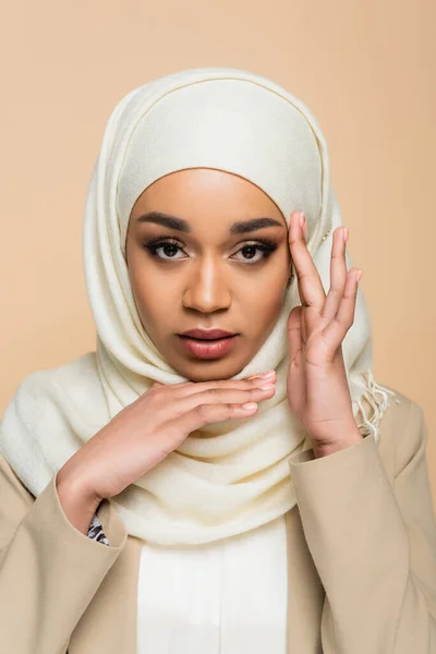 Portrait of young muslim woman in hijab with makeup isolated on beige — Stock Photo