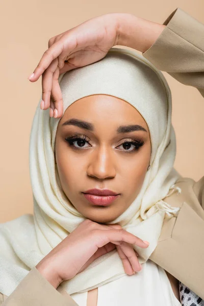 Portrait of pretty muslim woman in hijab with makeup isolated on beige — Stock Photo