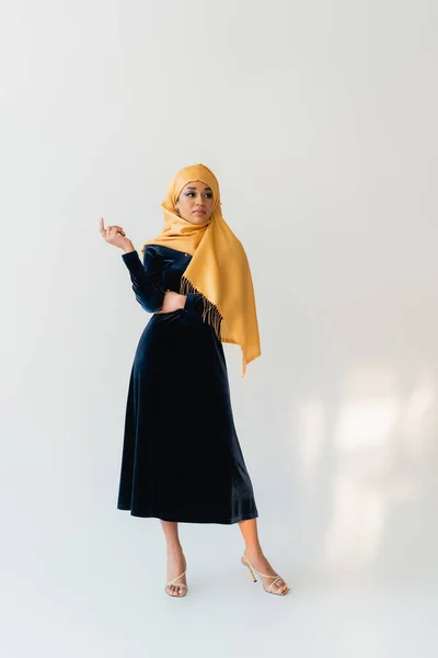Full length of muslim woman in hijab and velvet blue dress on white — Stock Photo