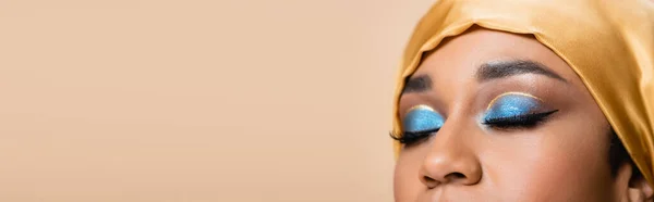 Cropped view of muslim woman in hijab with bright eye makeup isolated on beige, banner — Stock Photo