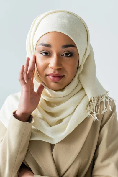 Hübsche muslimische Frau im weißen Hijab, die in die Kamera schaut, isoliert auf grau — Stockfoto