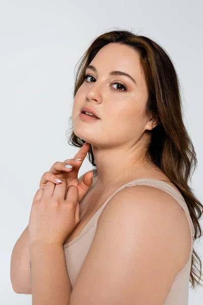 Portrait of pretty plus size woman looking at camera isolated on grey — Stock Photo