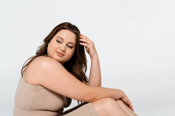 Junge brünette Frau mit Übergewicht schaut isoliert von grau weg — Stockfoto