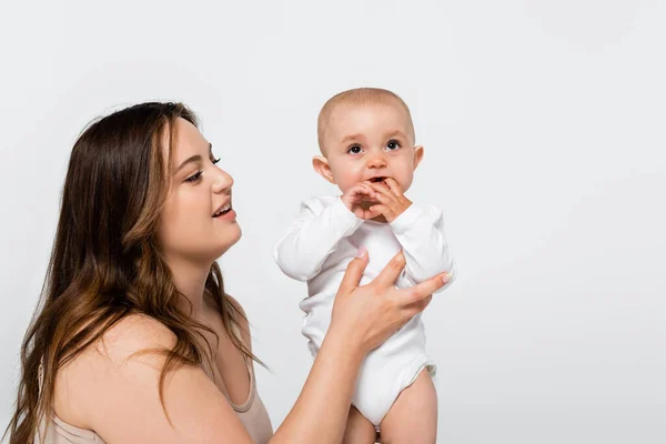 Junge Plus-Size-Mutter hält Baby-Mädchen isoliert auf grau — Stockfoto