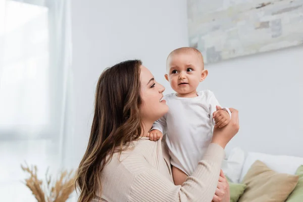 Glückliche Frau mit Übergewicht schaut Baby-Tochter zu Hause an — Stockfoto