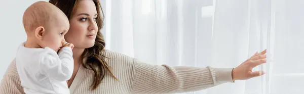 Corpo jovem mãe positiva segurando bebê perto de cortinas em casa, banner — Fotografia de Stock