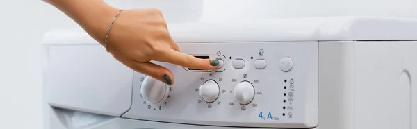 Partial view of woman pushing button on washing machine, banner — Stock Photo