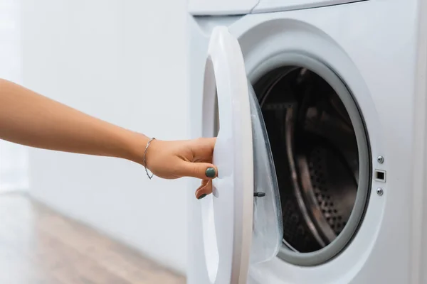 Vue recadrée de la femme au foyer ouverture machine à laver floue — Photo de stock