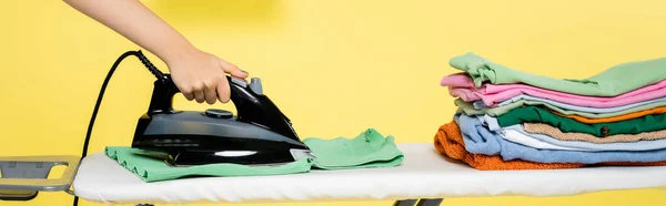 Обрізаний вид домогосподарки прасуючий одяг на жовтому, банер — стокове фото