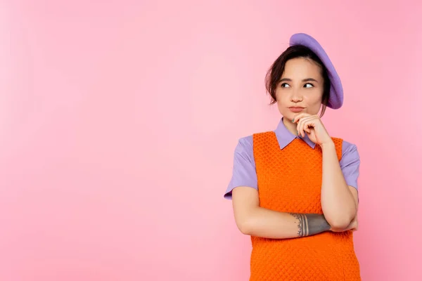 Donna premurosa che si tiene per mano vicino al viso mentre guarda lontano isolato sul rosa — Foto stock